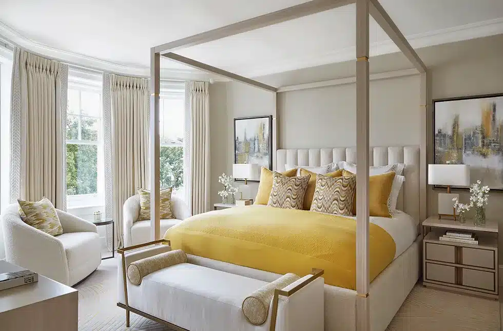 A master bedroom in yellow with a four poster bed in one of katharine pooleys luxury london projects
