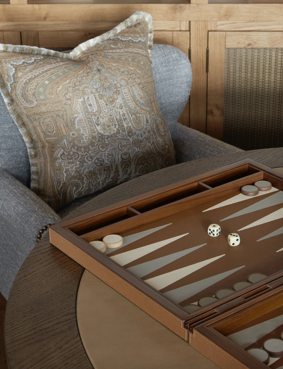 Cose up of paisley mocha throw pillow and backgammon set at a chalet design by uk top interior designer katharine pooley